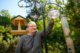 Oberzeller Schwester füllt die Futterschalen für die Vögel, ein gemeinsames Projekt mit dem LBV