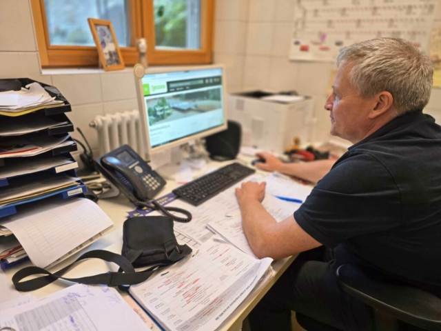 Küchenchef sitzt vor einem PC und nutzt moderne Technologien für die Bestellungen der Lebensmittel
