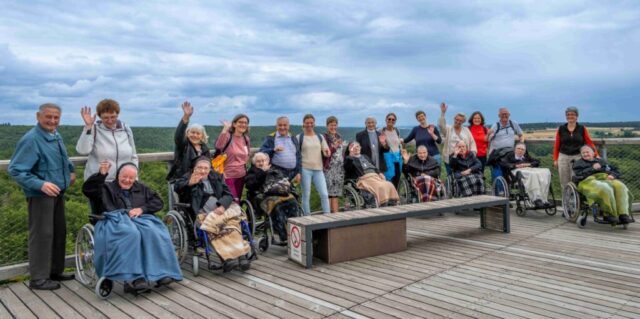 Gruppenfoto mit tollem Ausblick, einige winken in die Kamera.