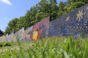 Mauer mit einem Mosaik, das den Sonnengesang darstellt