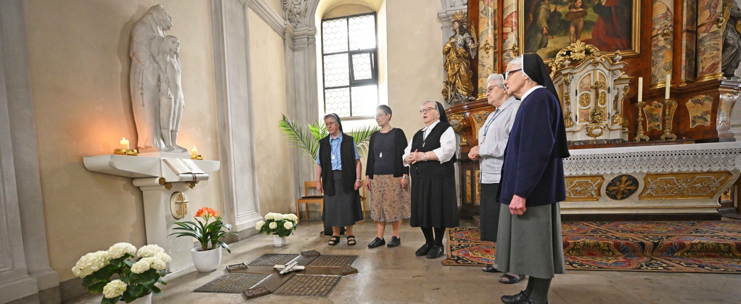 Oberzeller Schwestern beten in der Klosterkirche vor dem Grab von Antonia Werr.