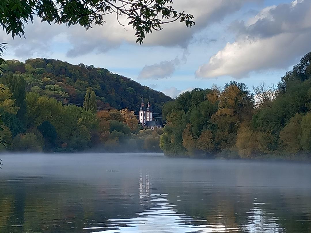 Main am Morgen mit Nebel, im Hintergrund die Kirchtürme vom Kloster Oberzell