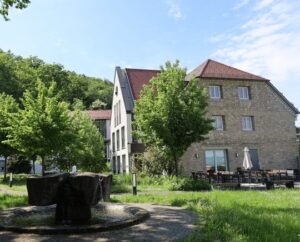 Tagungs- und Bildungshaus Klara von außen mit Terrasse und Brunnen