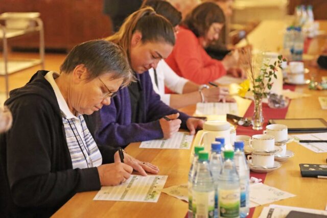Schwestern und Mitarbeitende füllen im Refektorium einen Bogen aus: Ein Ernährungsspiel brachte Dynamik und Spass am Gesundheitstag im Kloster Oberzell.