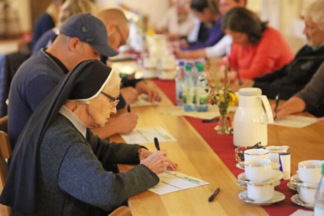 Schwestern und Mitarbeitende füllen im Refektorium einen Bogen aus: Ein Ernährungsspiel brachte Dynamik und Spass am Gesundheitstag im Kloster Oberzell.
