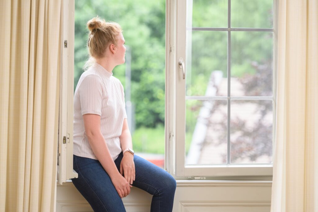 Junge Frau schaut aus dem Fenster