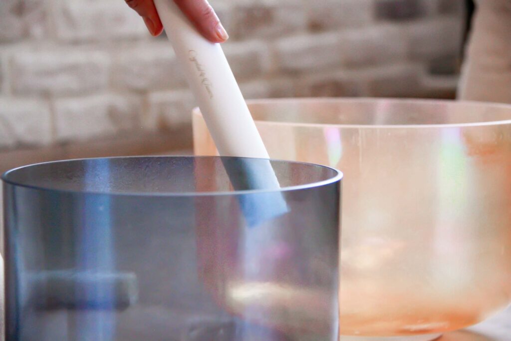 Zwei Klangschalen, eine wird berührt