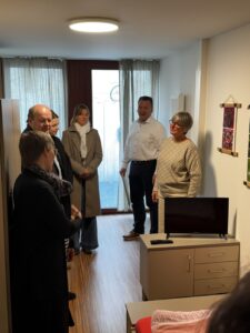 Fachbereichsleiterin Ute Berger zeigt den Gästen ein Zimmer für obdachlose Frauen im Haus Antonia Werr